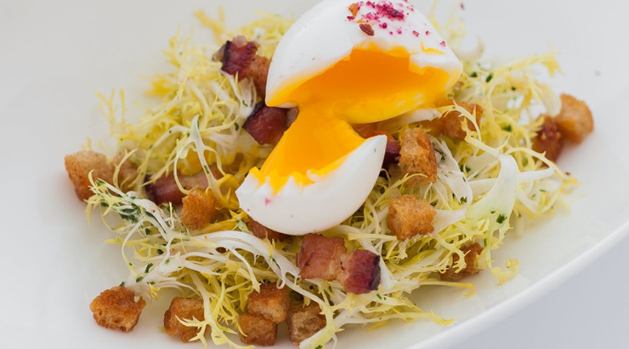 Frisee aux Lardons at The Bocuse Restaurant at the Culinary Institute of America, Hyde Park. Frisee aux Lardons is a salad made with endives, a poached egg and bacon.